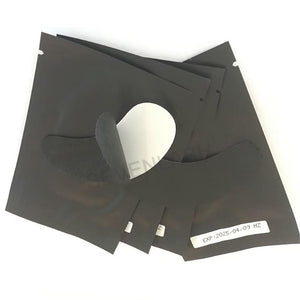 Texture close-up of black lint-free eye pad showing smooth surface and tear line